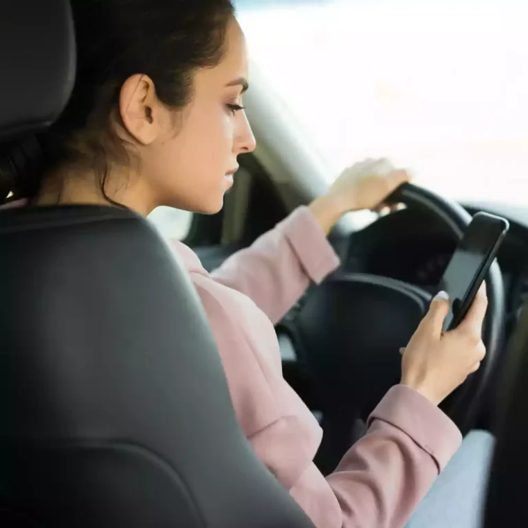 woman-steering-wheel-using-her-phone
